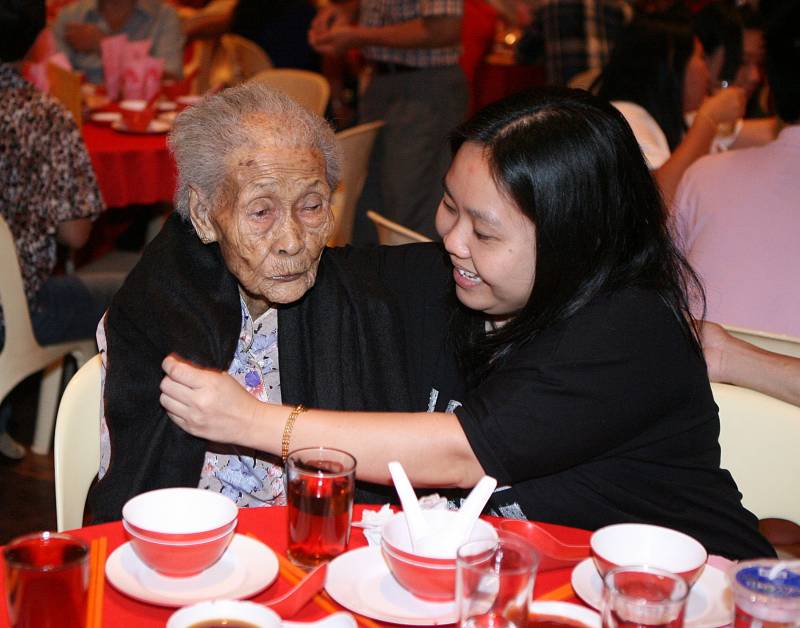 百岁老宝宝杜新（左）获得孙女冯慧芬的悉心照料，一会儿为怕冷的她披上外套，一会儿又喂她吃饭。