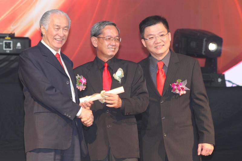 陈凯希（左）与赵汝祥（右）颁发奖状，表扬加入海鸥直销公司19年的皇冠钻石业务促进理事会成员之一陈忠顺。