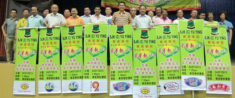 李传财（右9）及家协主席萧曾川（右10）率领育英小学“爱华教”义演工委会成员展示热心商家赞助的义演宣传布条，加强当地造势活动。