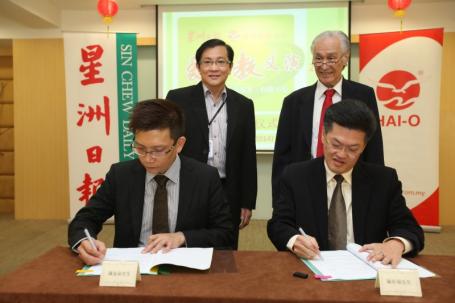 陈金泉（坐者左一）和陈祈福在“爱华教义演2014”推介仪式上签署合作协议书，由许春（站者左一）和陈凯希见证。
