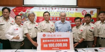 陈凯希（右4）将10万令吉的模拟支票交给翁清玉（左4），左起是江坤粦、蓝傑豪、陈松青，右起为刘志华、韩学林及吴国文。
