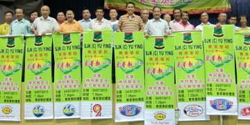 李传财（右9）及家协主席萧曾川（右10）率领育英小学“爱华教”义演工委会成员展示热心商家赞助的义演宣传布条，加强当地造势活动。