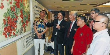 洪来喜（前排左起）、周斌、陈凯希、李传锡和陈国明一同观赏李传锡的荔枝画，后排为陈景岗。