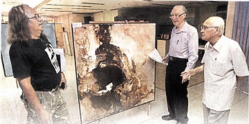 达因南利（左）向陈凯希（中）及乌斯曼阿旺基金会主席赛胡申阿里介绍其中一幅画。