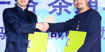 陈景岗（左）与施继泉签署了解备忘录后握手致意。